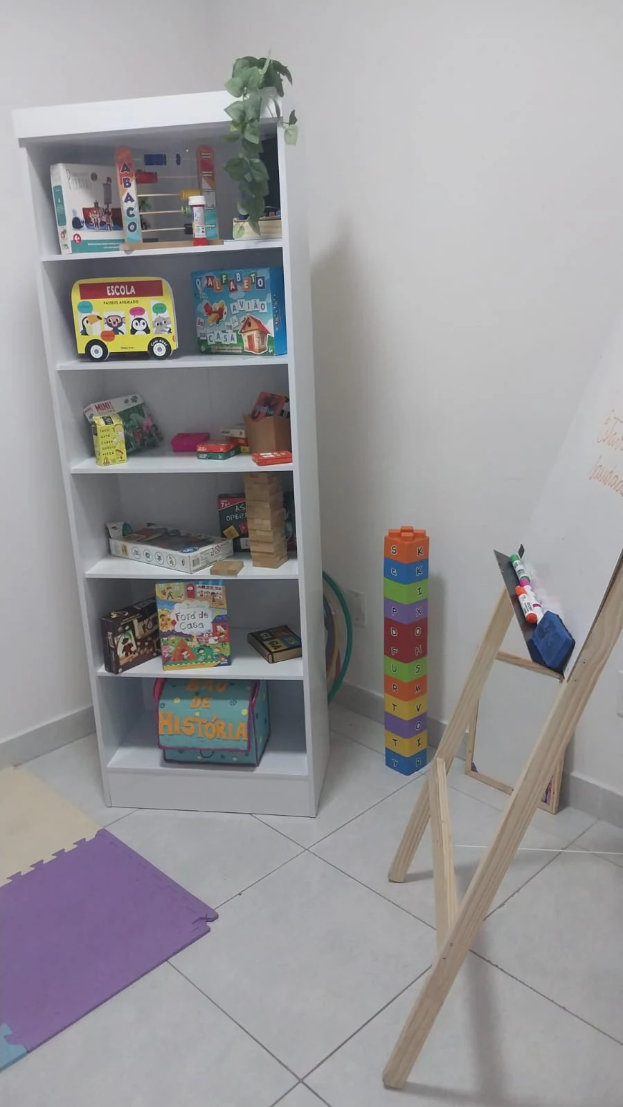 Espaço de aprendizagem da Atypical com livros, jogos educativos, lousa e tapete colorido